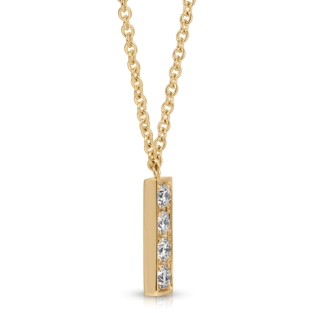 Gold necklace with a bar-shaped pendant featuring three diamonds on a white background