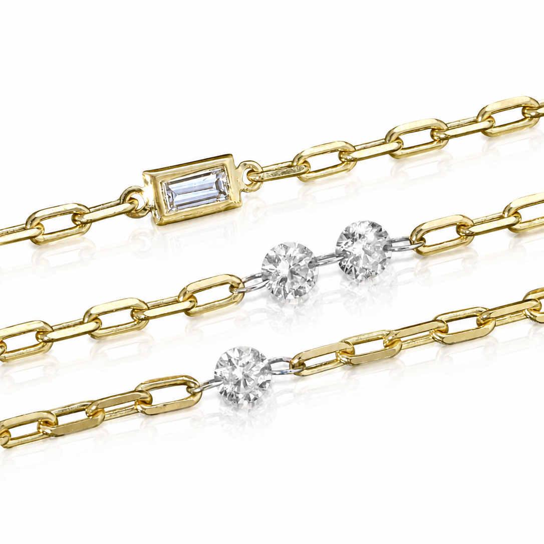 A close-up of a gold chain necklace with a rectangular baguette-cut clear gemstone clasp, alongside two matching chain segments featuring round clear gemstones on a white background.
