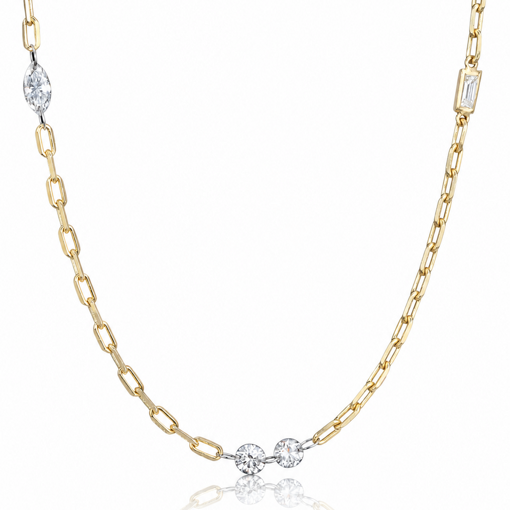 A delicate gold chain necklace featuring three small round-cut clear gemstones at the center, with additional clear stones set at intervals along the chain, displayed on a clean white background with a soft reflection below.