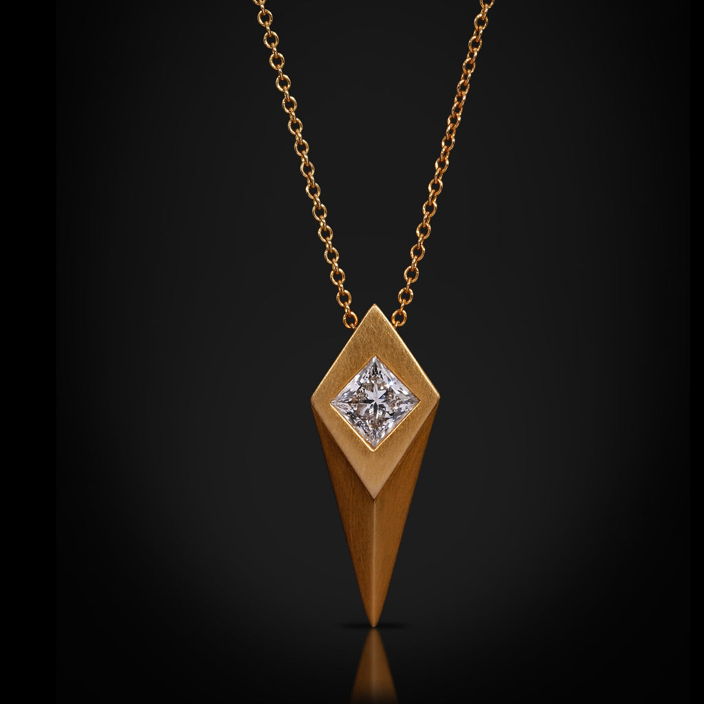 Gold necklace with a diamond pendant on a black background