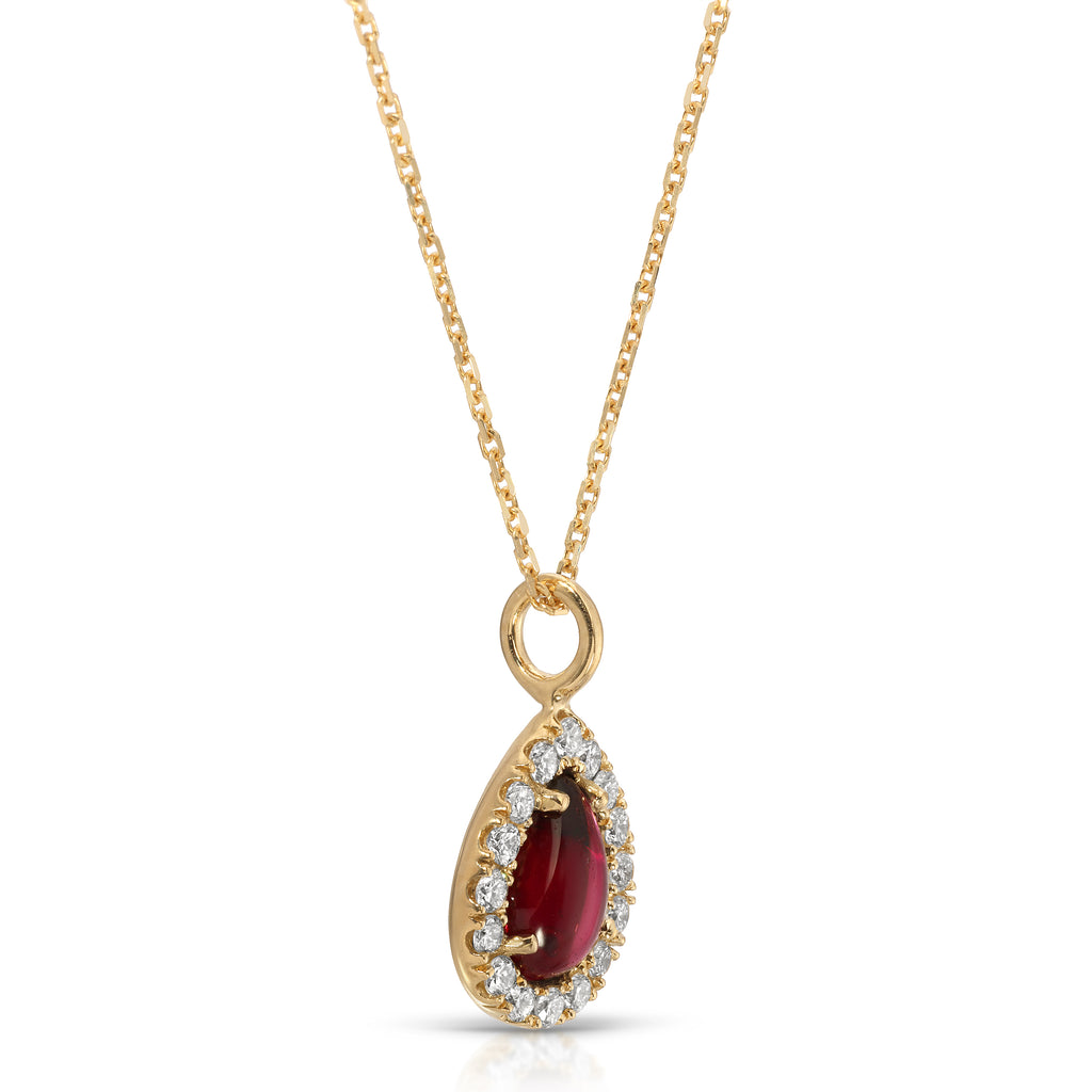 Gold necklace with a teardrop-shaped pendant featuring a red gemstone and clear stones on a white background.