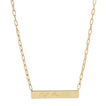 A gold bar necklace with a rectangular pendant engraved with the words 'Just Like That' in cursive script, suspended from a paperclip chain on a white background.