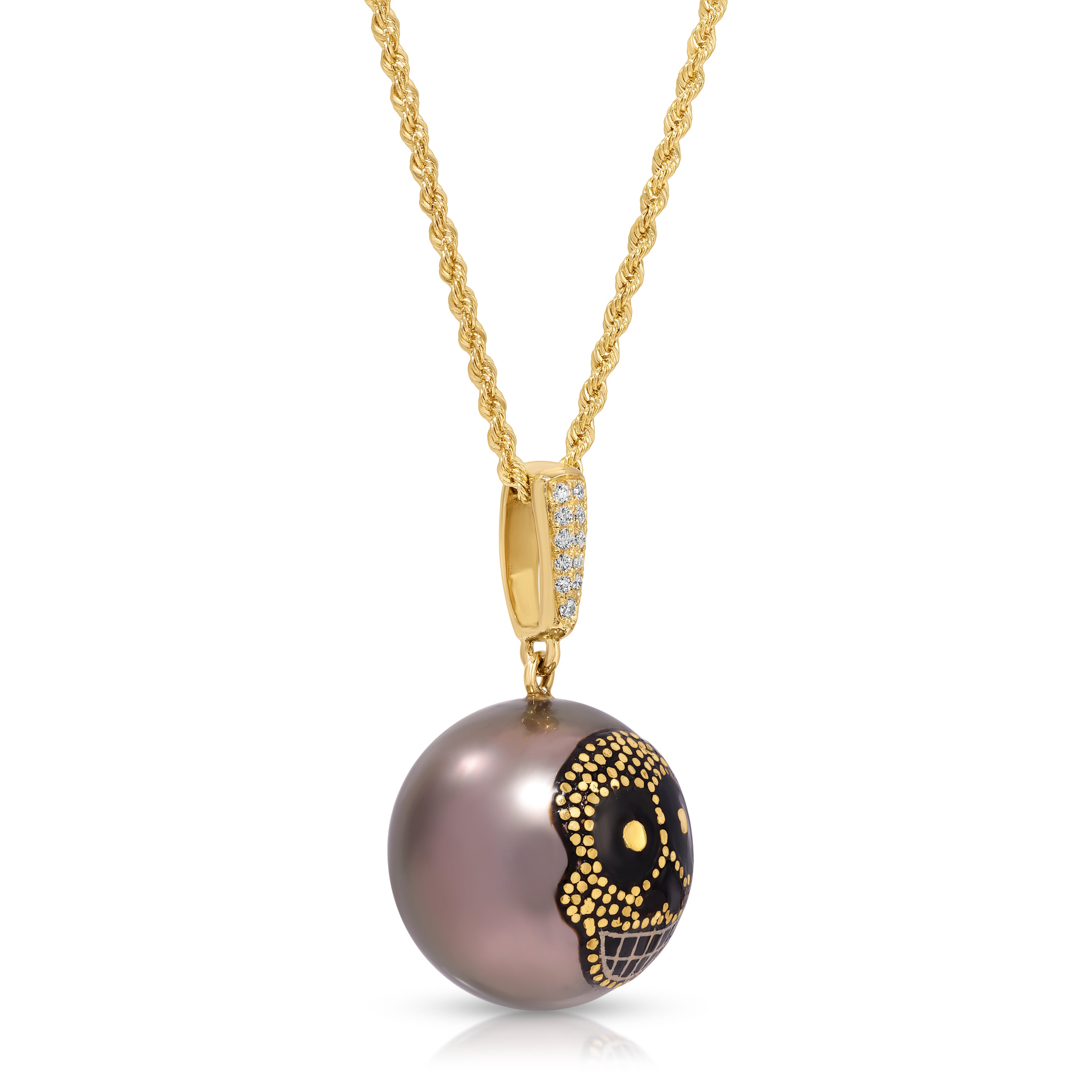 A gold necklace with a pendant featuring a dark grayish-purple pearl decorated with a black and gold sugar skull design, shown on a white background.