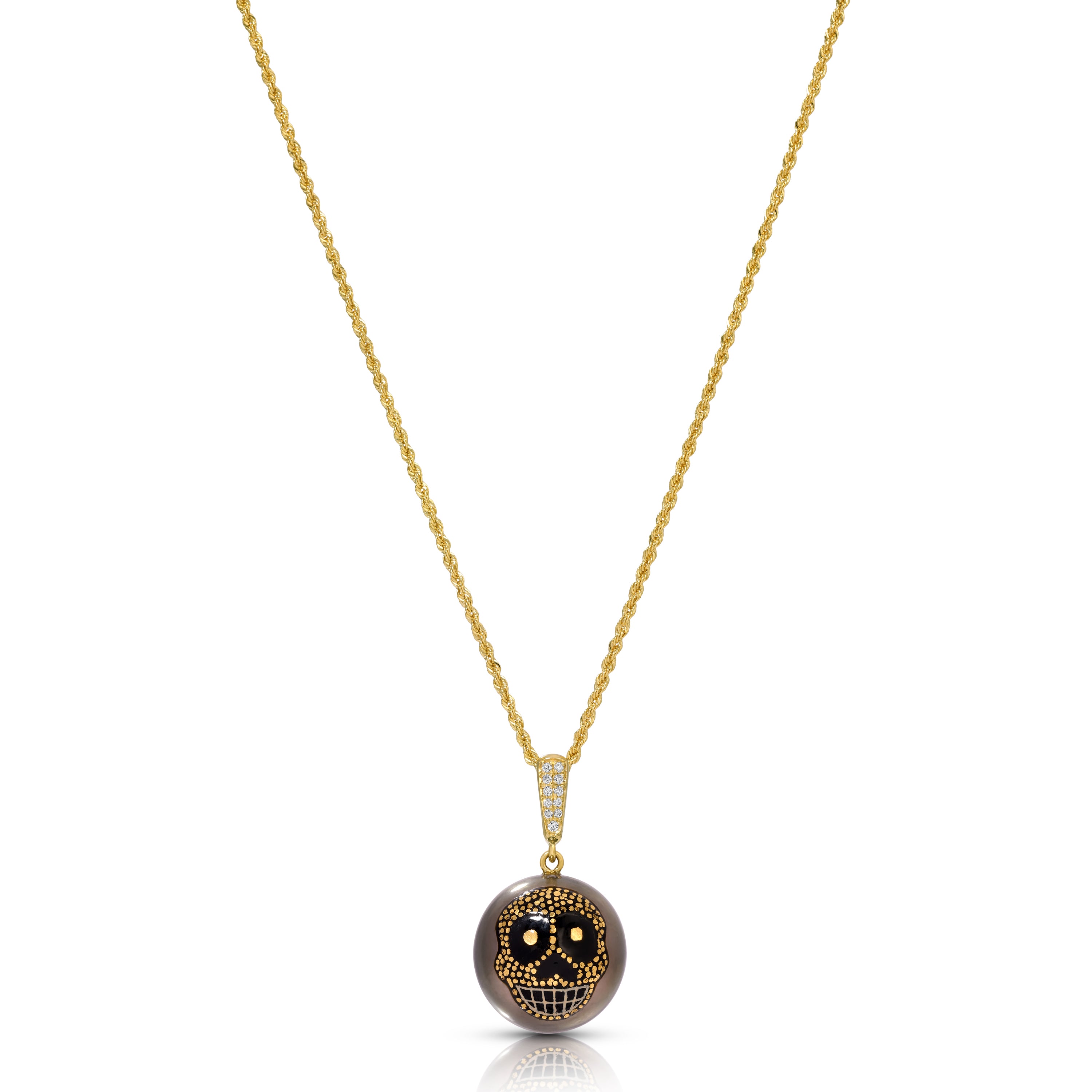 A gold chain necklace with a round pendant featuring a detailed skull design in black and gold, set against a plain white background.